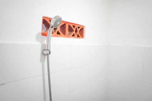 a shower with a shower head in a bathroom at RedDoorz Syariah @ Buduran Sidoarjo in Buduran