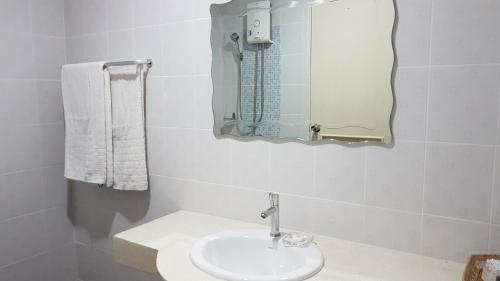 een witte badkamer met een wastafel en een spiegel bij Paknampran 2 Bedrooms Pool Villa in Pran Buri