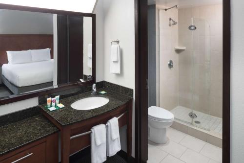 a bathroom with a sink and a toilet and a shower at Hyatt Place Jacksonville Airport in Jacksonville