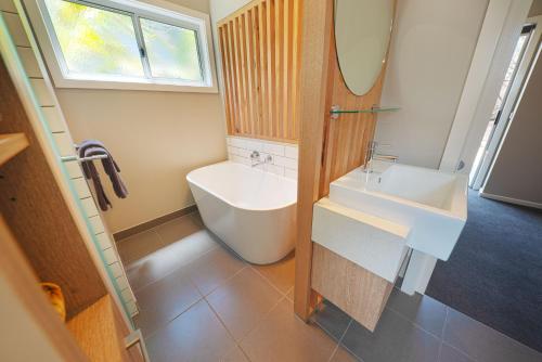 y baño con lavabo blanco y espejo. en NRMA Tathta Beachfront Holiday Park, en Tathra