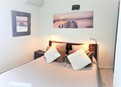 - une chambre avec un lit doté de draps et d'oreillers blancs dans l'établissement T2 avec jardin, piscine, vue mer à Saint-Gilles-les-Bains, à Saint-Gilles les Bains