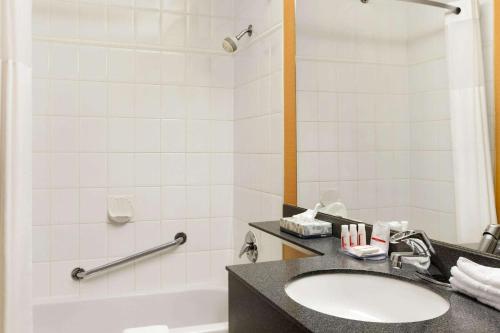 a bathroom with a sink and a tub and a toilet at Days Inn by Wyndham Vancouver Downtown in Vancouver