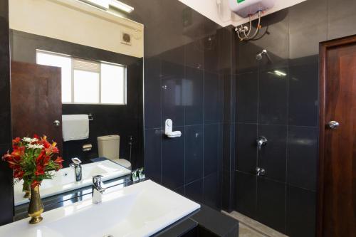 a bathroom with a sink and a shower at Ovi Court City Apartments Nuwara Eliya in Nuwara Eliya