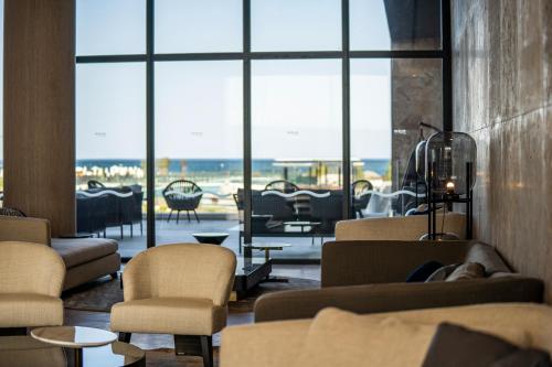 un vestíbulo con sofás y sillas y una gran ventana en Wave Resort - Ultra All Inclusive en Pomorie