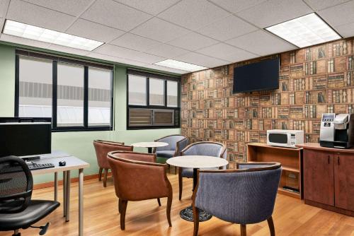 a waiting room with tables and chairs and a tv at Days Inn by Wyndham Vancouver Downtown in Vancouver