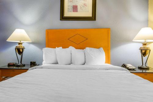 a bed in a hotel room with two lamps at Inn at Lebanon - Hershey & Manheim area in Lebanon
