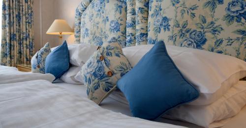 a bedroom with blue and white pillows on a bed at Sunny Brae Bed & Breakfast in Nairn