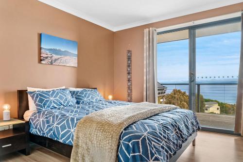 a bedroom with a bed and a large window at Freycinet Dream in Coles Bay