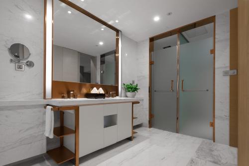 a bathroom with a sink and a mirror at Gallery F Hotel in Wuhan