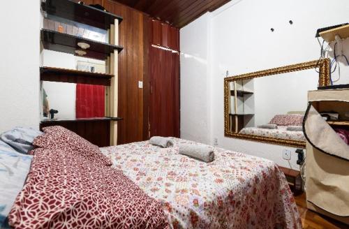 1 dormitorio con cama y espejo en Kitinete Ipanema, en Río de Janeiro