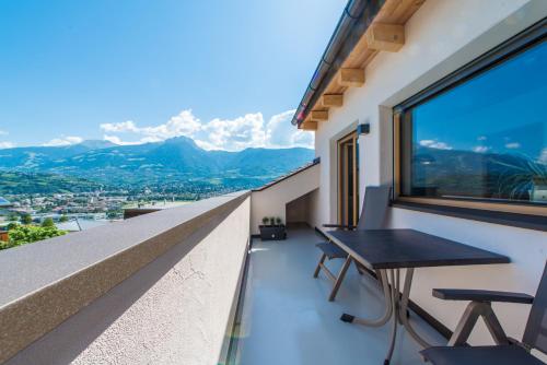 a balcony with a table and chairs and mountains at Eco Bnb & Apartments Bründlerhof in Marlengo
