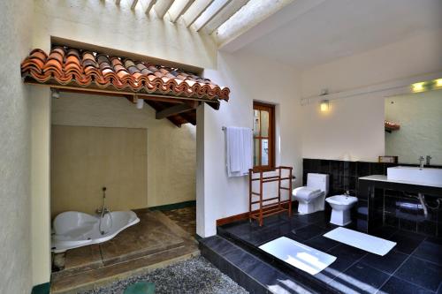 a bathroom with two toilets and a sink and a tub at Hibiscus Beach Hotel & Villas in Kalutara
