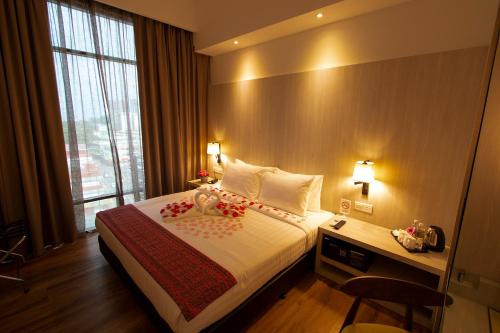 En eller flere senge i et værelse på AZ Hotel & Serviced Apartments