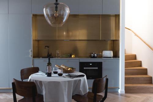 a kitchen with a table and chairs and a kitchen with stairs at Bob W Koti Ullanlinna in Helsinki