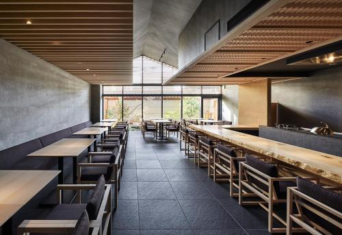 a dining room with wooden tables and chairs at ONSEN RYOKAN YUEN SHINJUKU in Tokyo