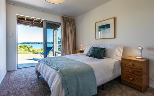 a bedroom with a bed and a large window at Tui Point in Surfdale