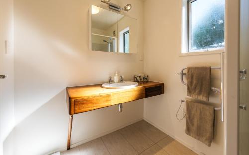 a bathroom with a wooden sink and a mirror at Tui Point in Surfdale