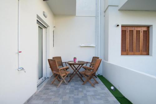 a patio with a table and chairs and a window at Skalidis Apartments Stalis in Stalida