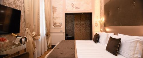 a hotel room with a bed and a television at Santa Croce Boutique Hotel in Venice