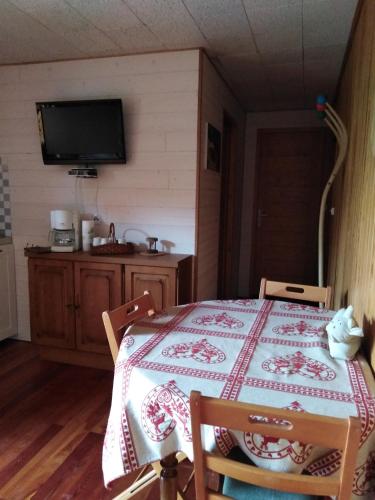 une pièce avec une table et une télévision sur un mur dans l'établissement PRA BIQUET, à Les Thuiles