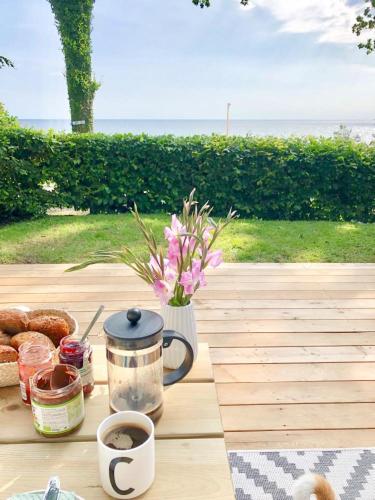 una mesa con pastas y una taza de café y flores en Ferienwohnung Baltic Sea Room, en Scharbeutz