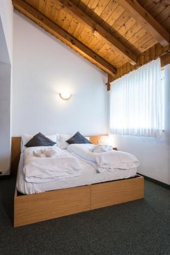 a bed with a wooden frame in a room at Hotel El Paso in Fai della Paganella