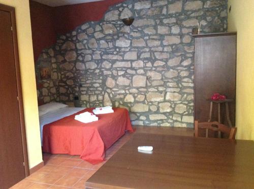 a room with a stone wall with a bed in it at Vento Del Sud in Chiaramonte Gulfi