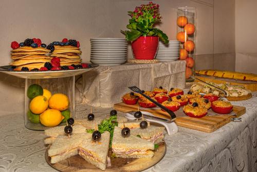 un buffet con sándwiches, fruta y platos de comida en Hotel Villa Rinascimento, en Lucca