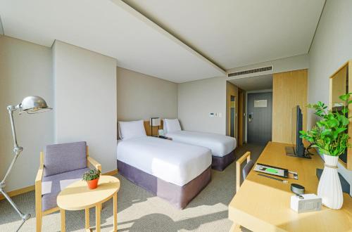 a hotel room with a bed and a table and a room at Harbor Park Hotel in Incheon