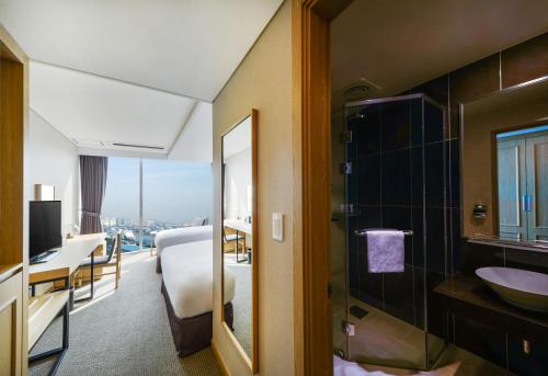 um quarto de hotel com casa de banho com lavatório e espelho em Harbor Park Hotel em Incheon