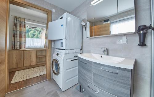 W łazience znajduje się pralka i umywalka. w obiekcie Holiday Lodge Fürst w Saalbach Hinterglemm