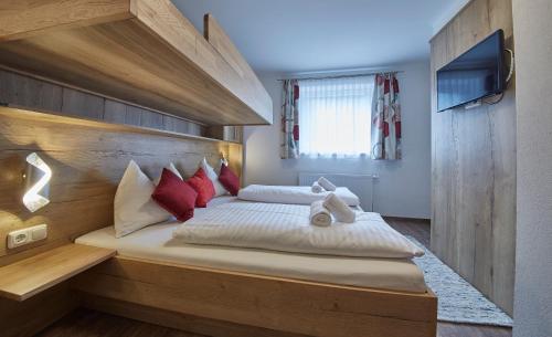 sypialnia z dużym łóżkiem z czerwonymi poduszkami w obiekcie Holiday Lodge Fürst w Saalbach Hinterglemm