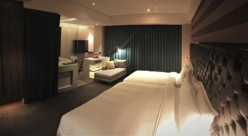 a hotel room with a large bed and a bathroom at Starhaus Hotel in Kaohsiung