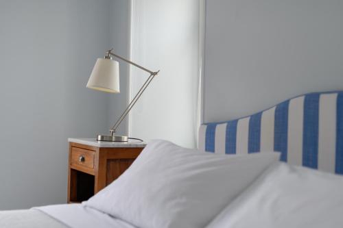 a bedroom with a bed with a lamp on a night stand at Hydras Chromata in Hydra