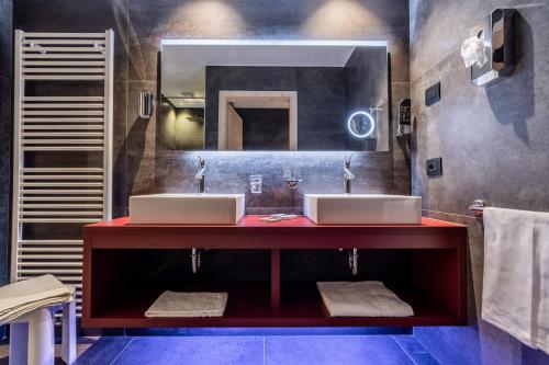 ein Badezimmer mit zwei Waschbecken und einem großen Spiegel in der Unterkunft Hotel Val Di Sole in Mezzana