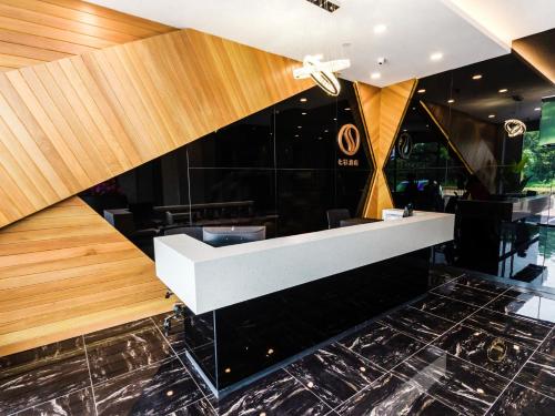 a lobby with a white counter and black tiles at Solid Hotels in Johor Bahru