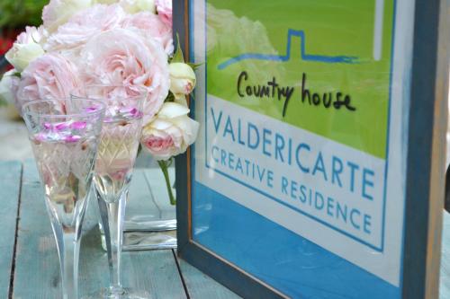 a vase of pink flowers next to a sign at ValdericArte in Lamoli Di Borgo Pace