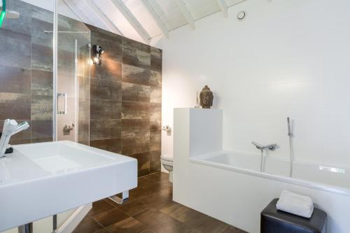uma casa de banho com uma banheira branca e um lavatório. em Rosa Arvensis em Lottum
