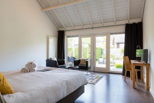 a bedroom with a bed and a sliding glass door at Rosa Arvensis in Lottum
