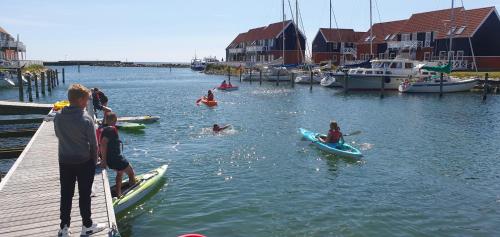 people in the water with surfboards at Klintholm Marina Park Cabins in Borre