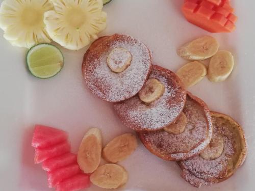 einen Teller mit Pfannkuchen und Obst darauf in der Unterkunft Wah Danima Resort & Restaurant in Gili Trawangan