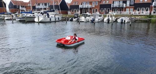 a man riding a boat in a body of water at Klintholm Marina Park Cabins in Borre