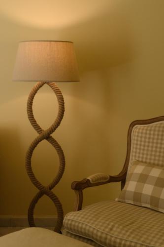 a floor lamp with a snake design next to a bed at Hydras Chromata in Hydra