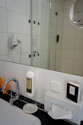 a bathroom with a sink and a mirror at Hotel Garni Inselparadies Zingst in Zingst