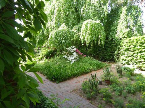 a garden with flowers and a brick walkway at Ferienwohnung Landhaus im Grünen in Bad Zwischenahn