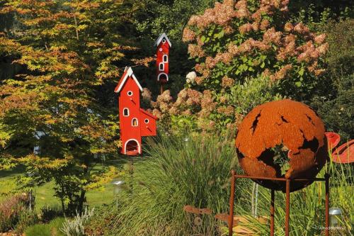 a garden with three small houses in the trees at Ferienwohnung Landhaus im Grünen in Bad Zwischenahn