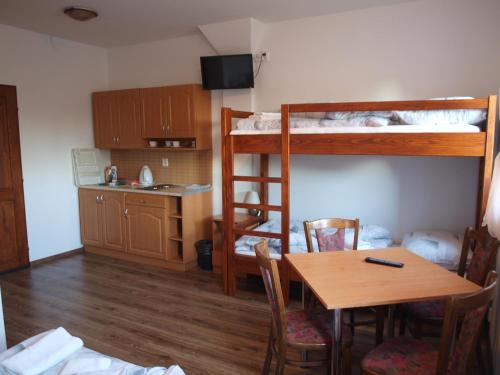 a room with a table and a dining room with bunk beds at penzion U Kmotra in Borovany