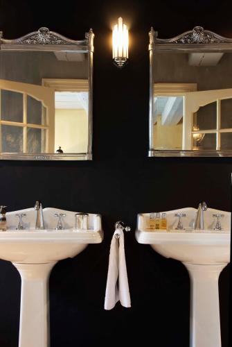 two sinks in a bathroom with mirrors and towels at Suitehotel Posthoorn in Monnickendam