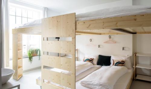 a room with two bunk beds and a bathroom at The Green Elephant Hostel & Spa in Maastricht