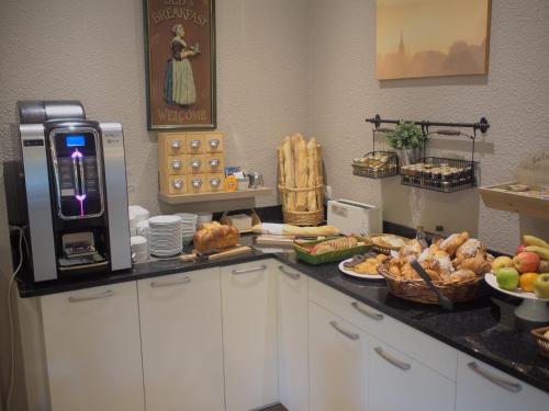 a kitchen with a counter with food on it at The Originals City, Hôtel et Restaurant Aster, Saint-Avold Nord in Creutzwald-la-Croix
